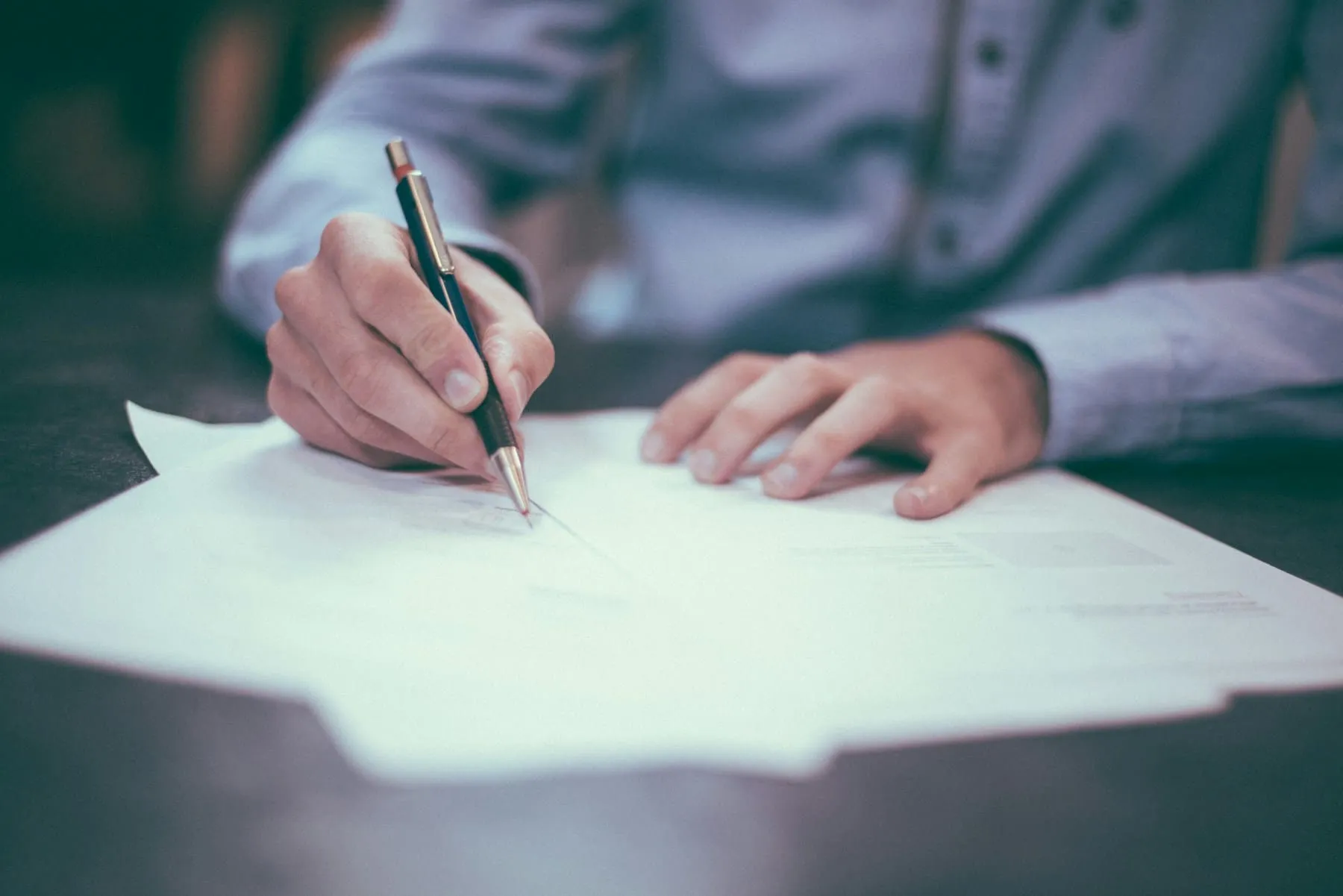 A buyer signing the purchase agreement